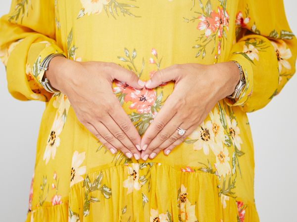 Hands held over pregnant belly 