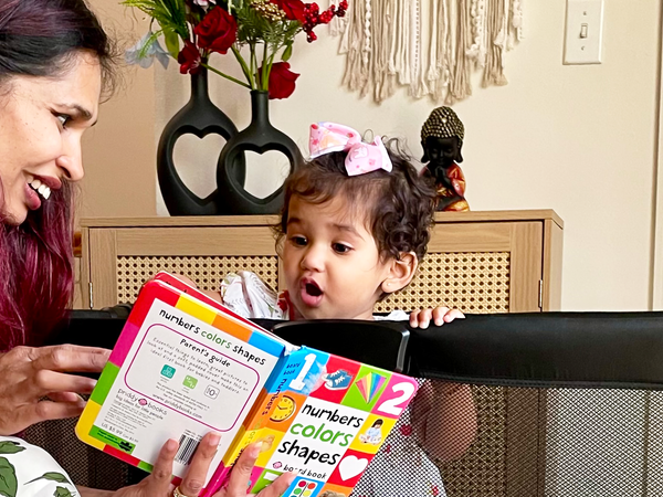 mom reading to baby in Breeze Playard